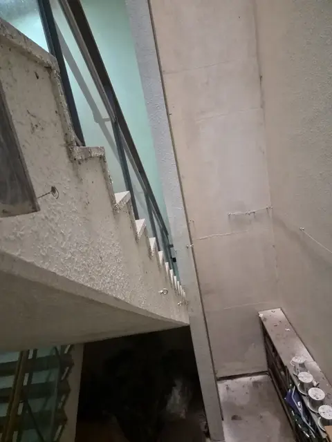 높은 층고의 계단실 아래에서 위로 올려다본 안전그물망 설치 현장